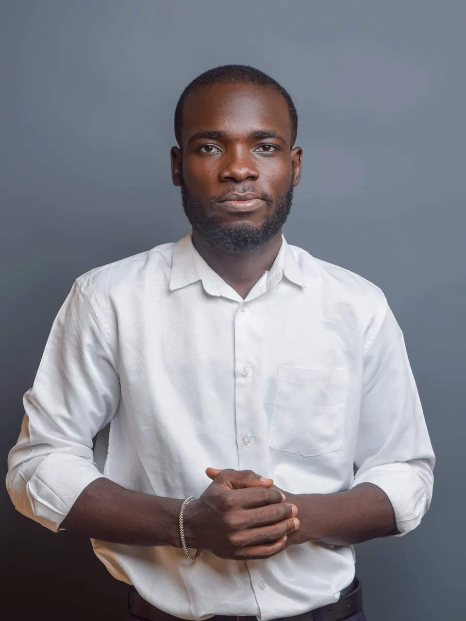 Jim Blessed, SEO expert in Lagos, standing in a white shirt with his hands clasped